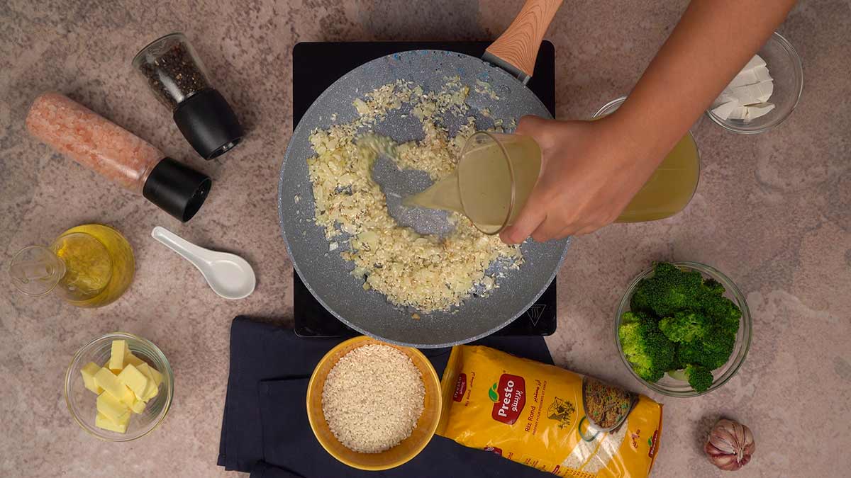 Ajout du première louche du bouillon de crevettes au riz