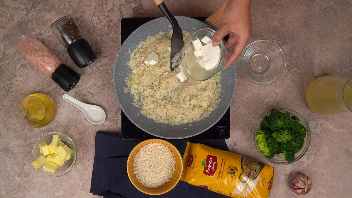 Ajout des cubes de fromage ricotta au riz et au mélange des ingrédients