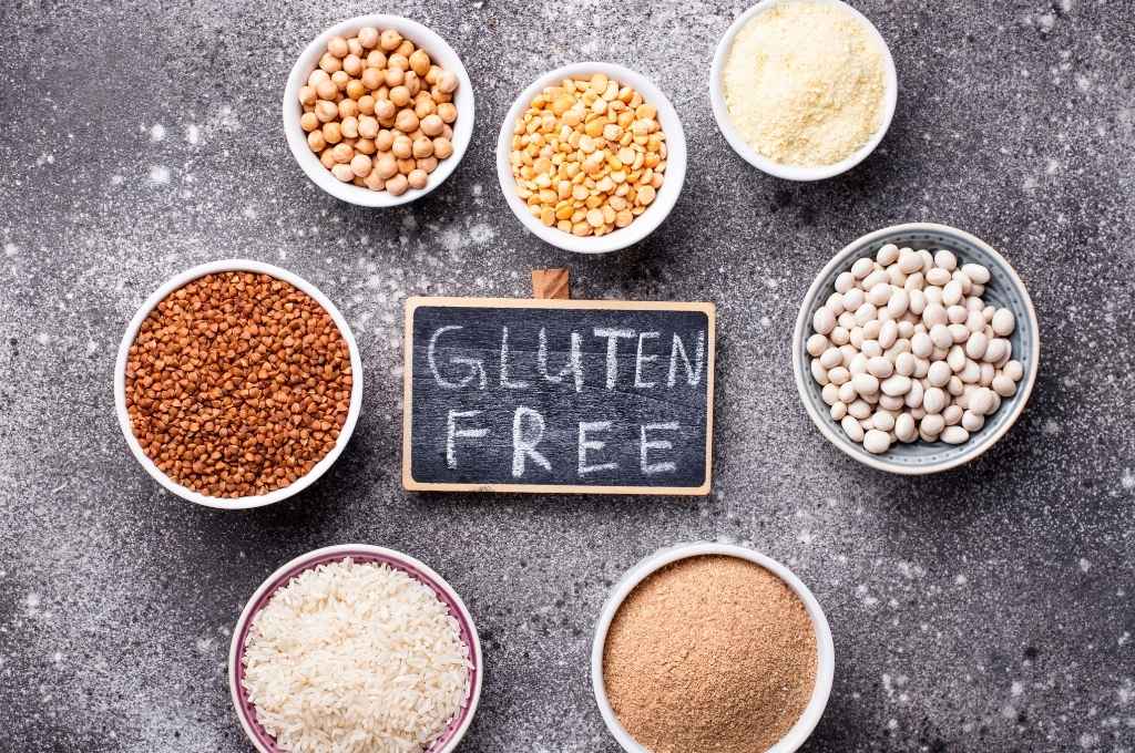 Un assortiment d'aliments sans gluten entourant une ardoise marquée "Gluten Free"