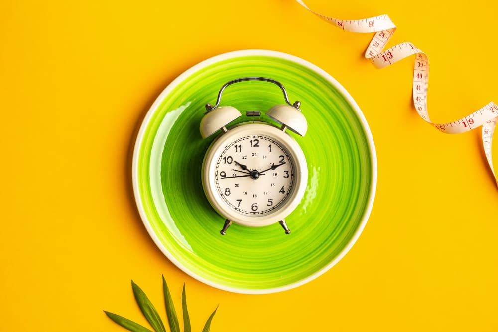 منبه أبيض على طبق أخضر، خلفية صفراء. شريط قياس في الأعلى يمين.