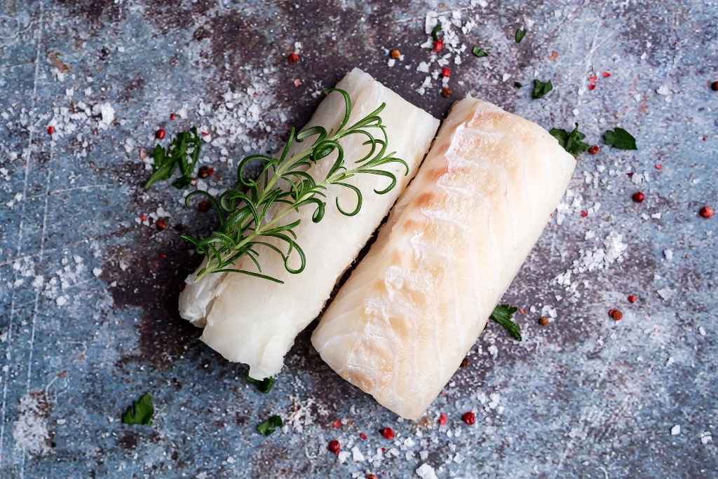 des filets de poisson cru accompagné d'un brin de romarin