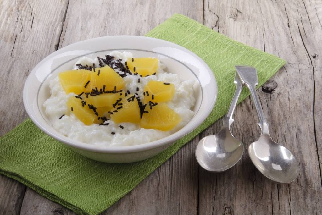 طبق أرز بحليب جوز الهند والأناناس على منديل أخضر مع ملعقتين