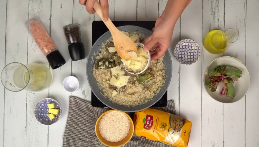 Ajout le parmesan au mélange de risotto comme étape finale avant de servir