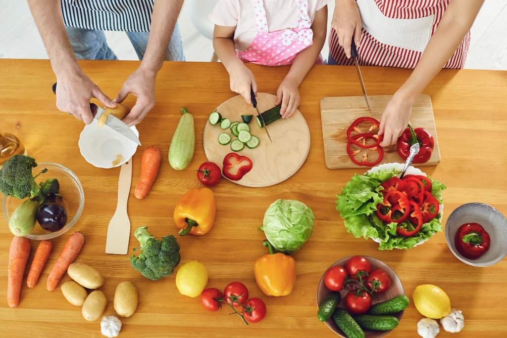 Famille coupant des légumes pour cuisiner.