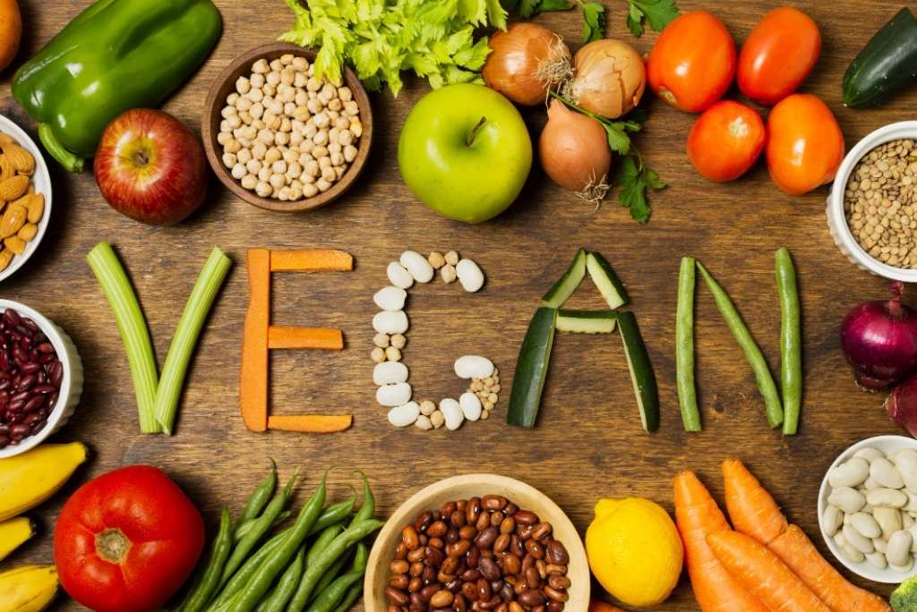  طاولة بها أطباق نباتية ملونة، بما في ذلك الخضار المشوية والسلطة والأرز والخبز، مع الأيدي التي تقدم