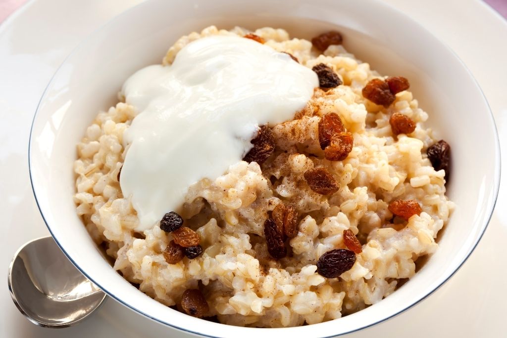 Bol de porridge de riz complet garni de yaourt et de raisins secs, pour un petit-déjeuner sain et nutritif
