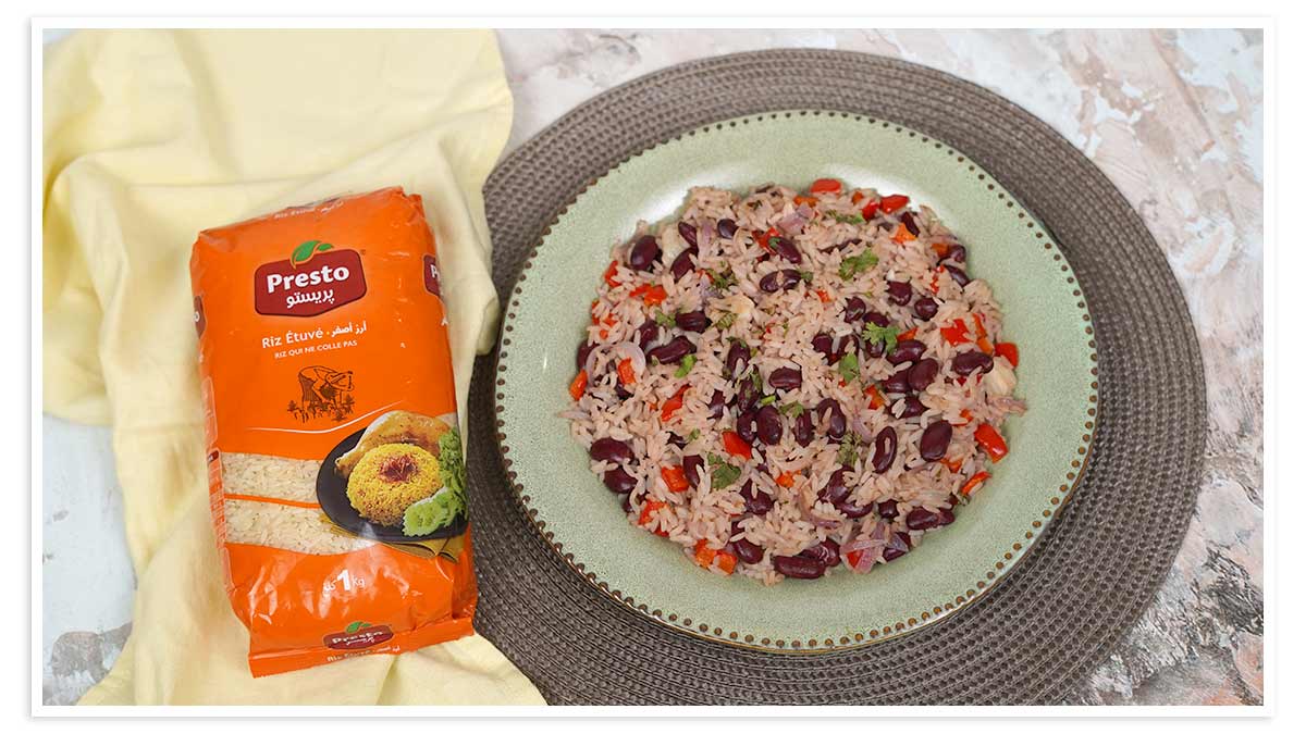 Un plat de riz congrí, avec des haricots rouges, des oignons et des poivrons, est servi dans une assiette verte.