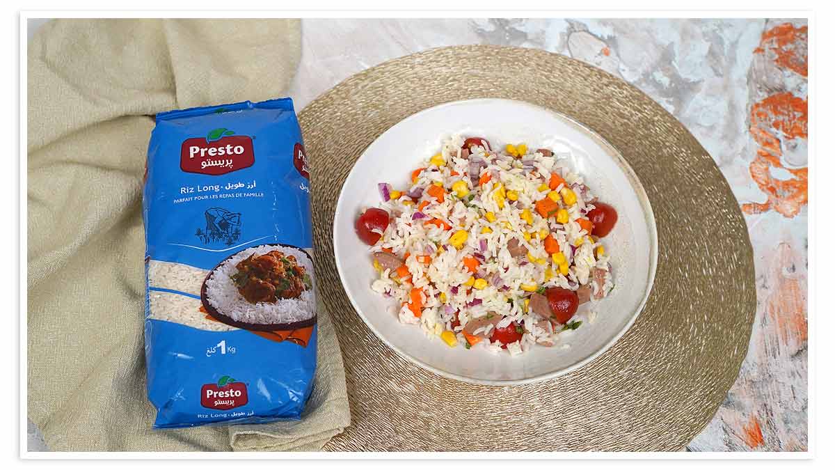 سلطة أرز صيفية زاهية الألوان، تحتوي على جميع مكوناتها، تُقدَّم في طبق أبيض.