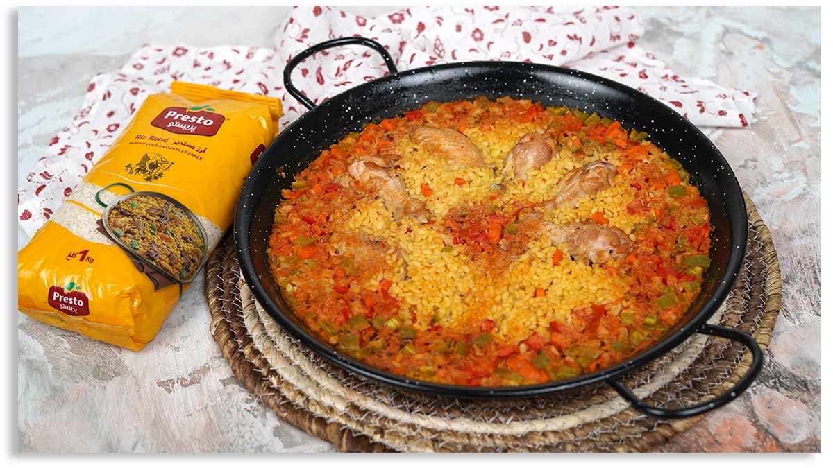 la paella maison est prête à être servie dans une grande poêle.