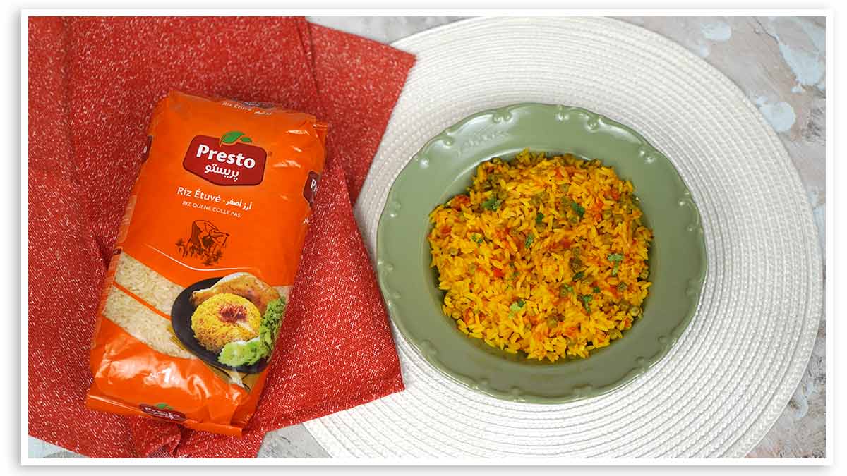 طبق من الأرز المكسيكي، مزين بحبات البازلاء والفلفل، يُقدَّم في صحن أخضر.