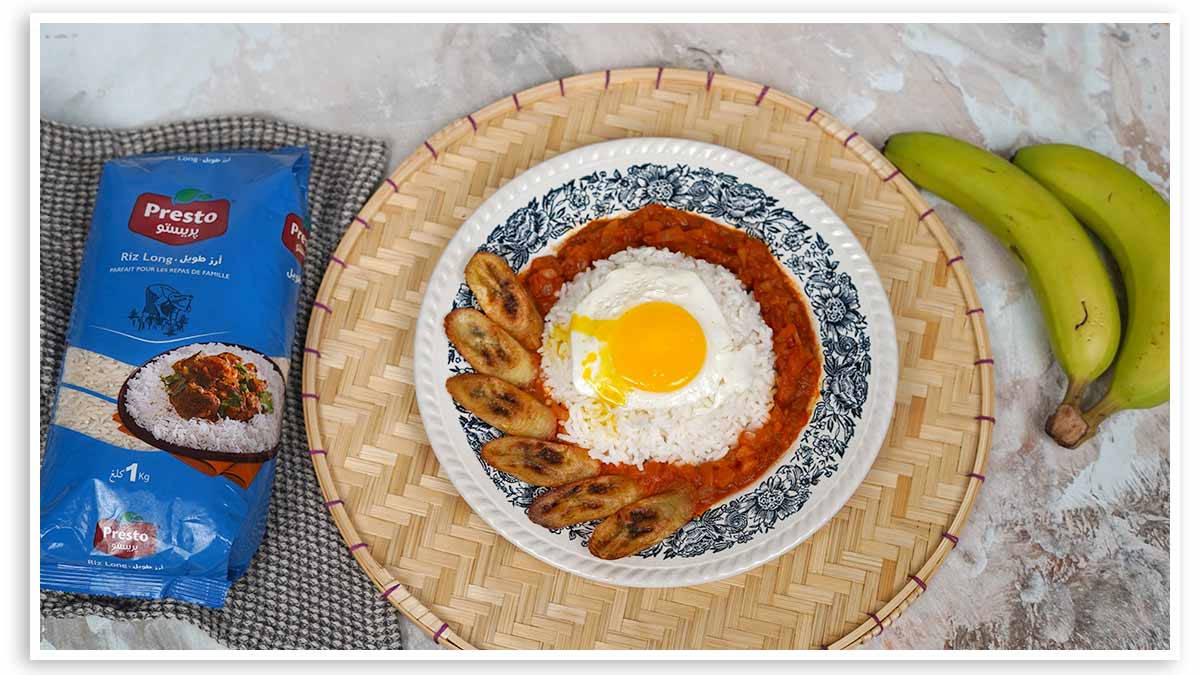 طبق أرز على الطريقة الكوبية، مع صلصته بالطماطم وشرائح الموز الأخضر المقلية وبيضة مقلية، يُقدَّم في طبق.