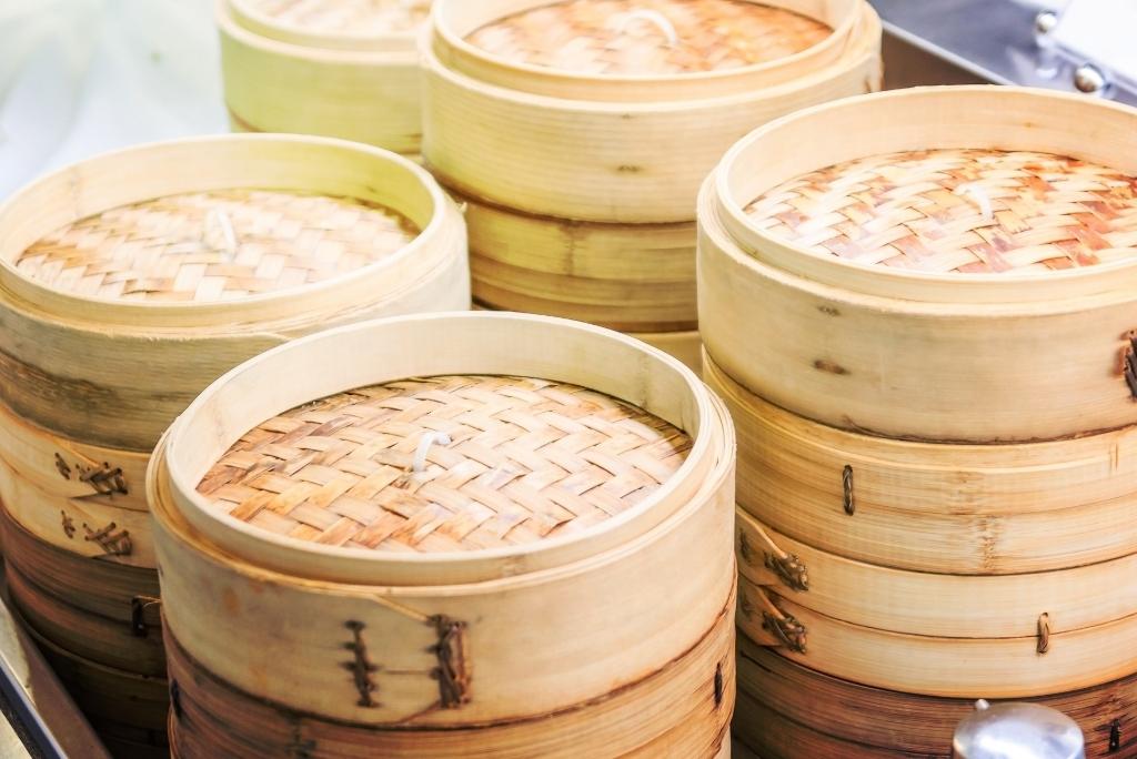 سلال طهي مصنوعة من الخيزران مكدسة فوق بعضها، مع ظهور أغطيتها.