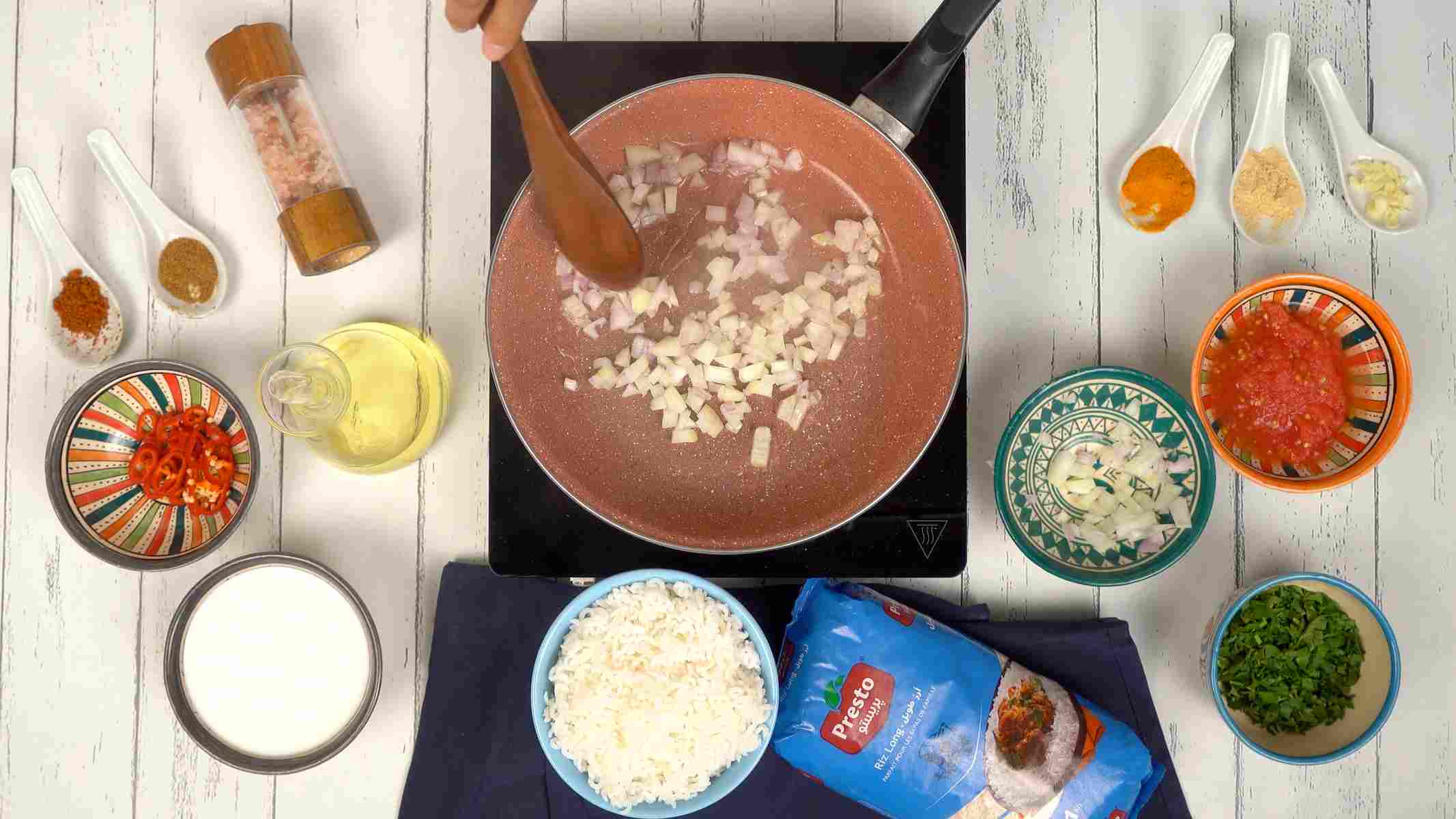 تشويح البصل والثوم شخص يقلب البصل المفروم في مقلاة.