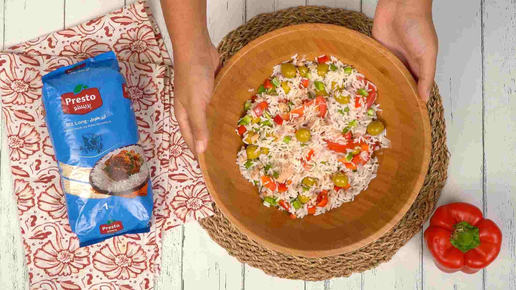 Servir et déguster Un grand bol de salade de riz, richement mélangé avec des olives, des poivrons et du thon, est prêt à être dégusté.