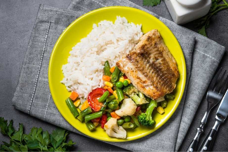 plat de poisson aux légumes sautés et du riz