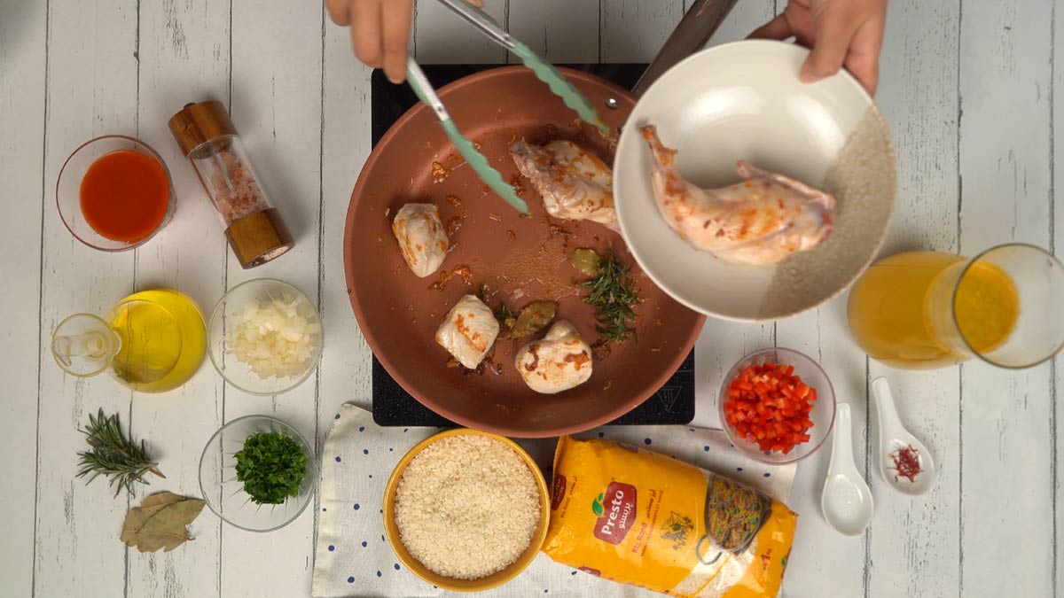 Faire dorer les viandes On commence par faire dorer les morceaux de poulet et de lapin dans une poêle avec de l'huile, du romarin et des feuilles de laurier.