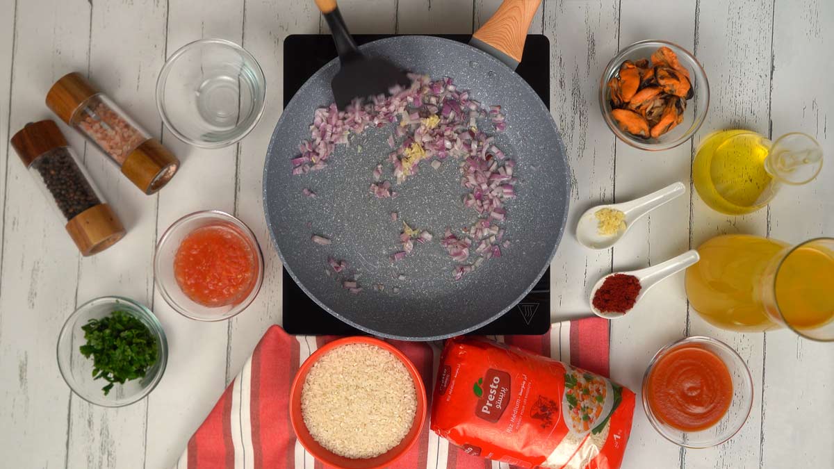 Faire revenir les aromates La cuisson commence par faire revenir les oignons rouges émincés et l'ail dans une poêle avec de l'huile.