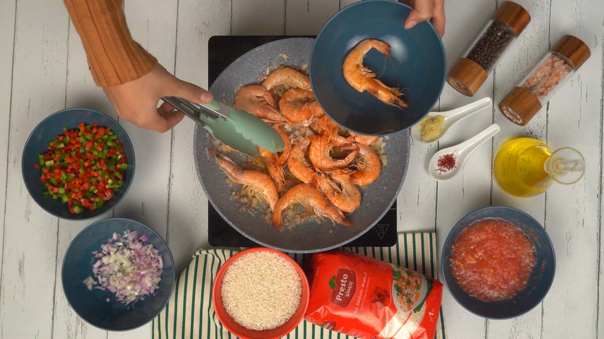 تبدأ عملية الطهي بتحمير القمرون في مقلاة مع البصل المفروم، ثم يُرفع ويوضع جانبًا في وعاء.