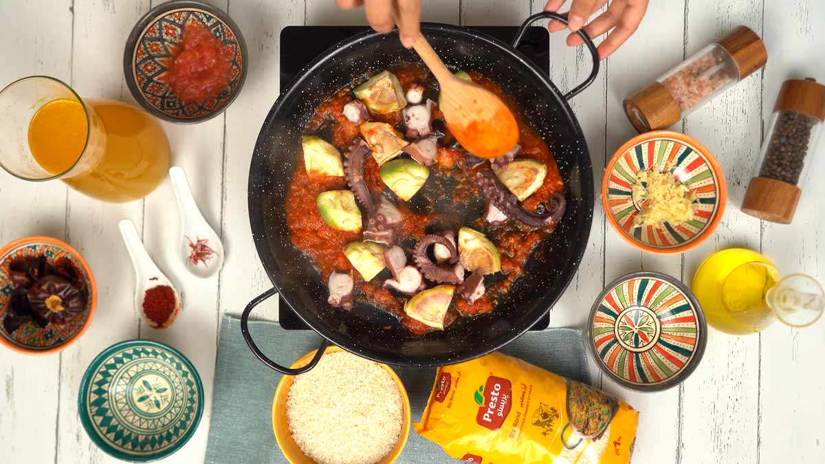 On incorpore les morceaux de poulpe cuit et les cœurs d'artichauts, en mélangeant bien pour qu'ils s'imprègnent des saveurs.