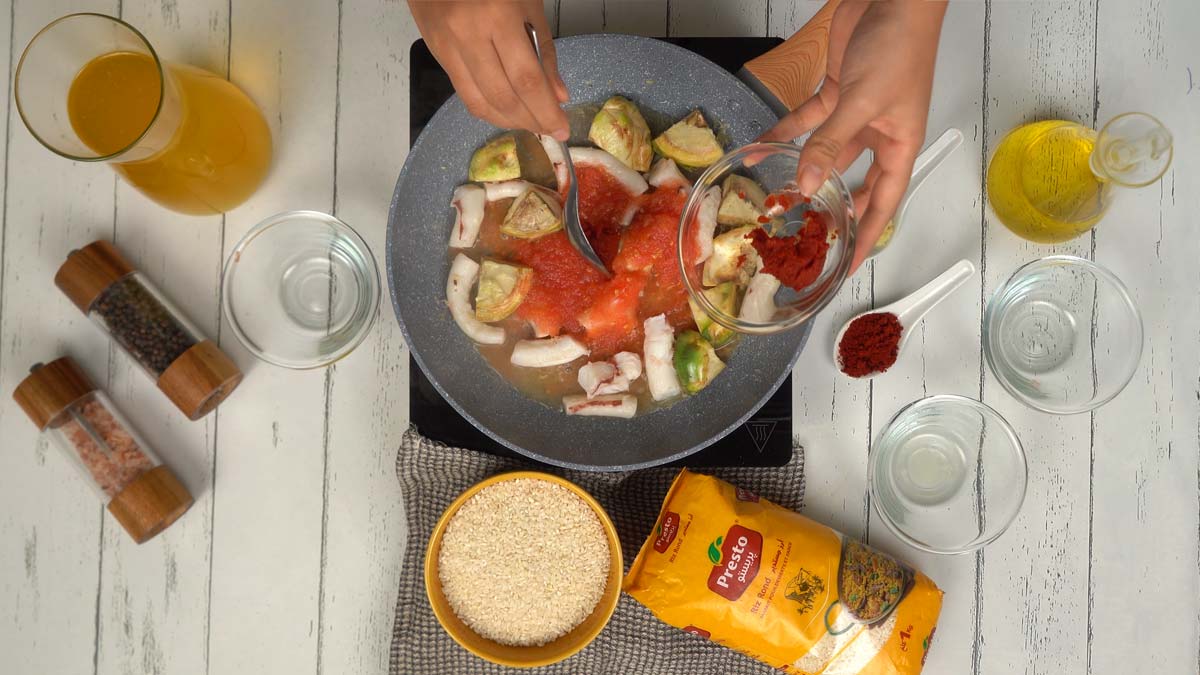 On ajoute la sauce tomate et une pointe de concentré de tomate pour lier et colorer la préparation.