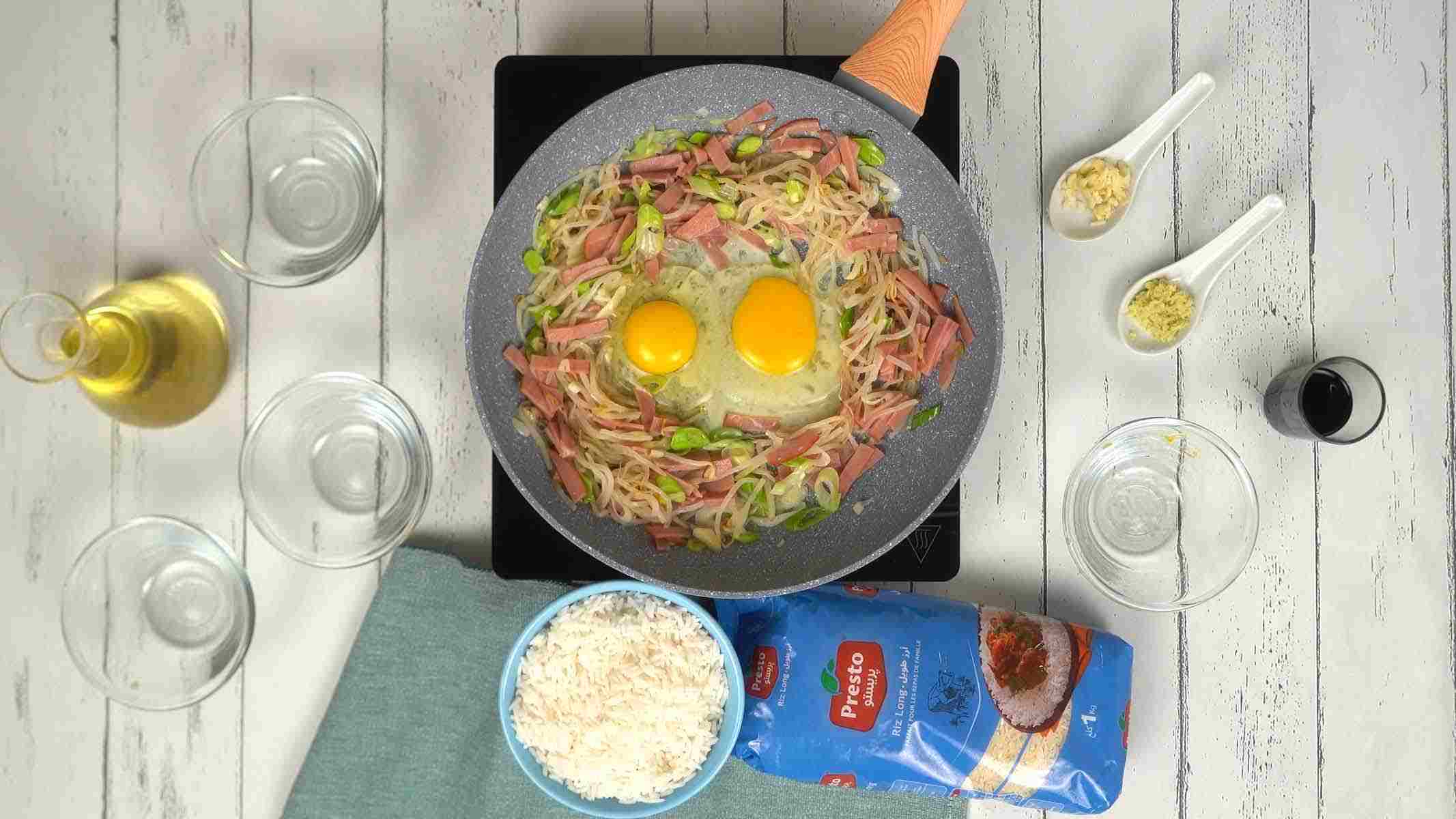 On casse deux œufs directement au centre de la poêle pour les brouiller avec les autres ingrédients.