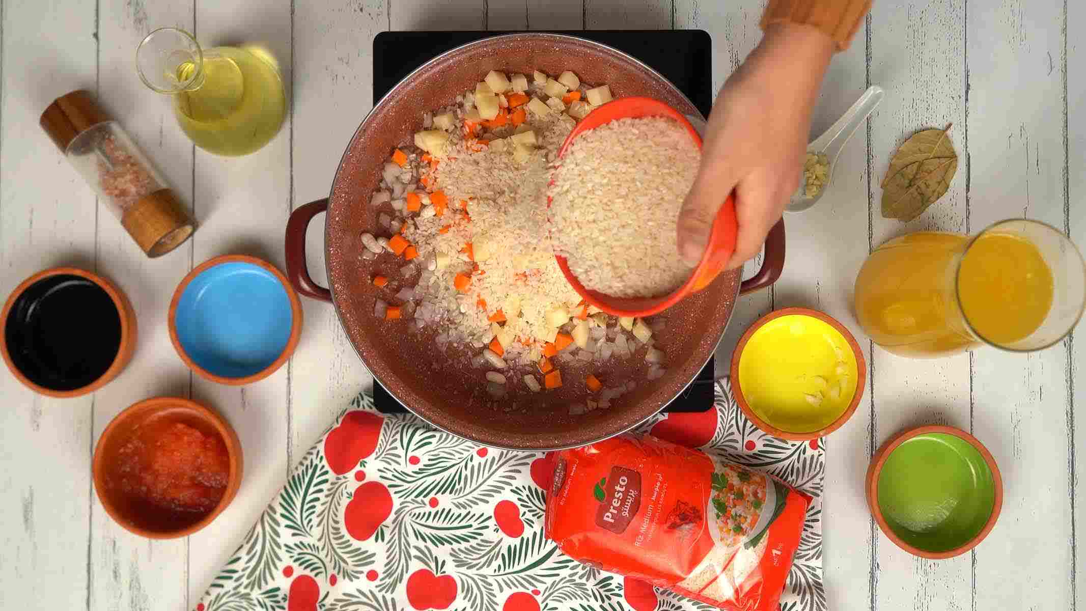 On verse le riz cru directement dans la marmite avec les légumes pour qu'il s'imprègne des saveurs.