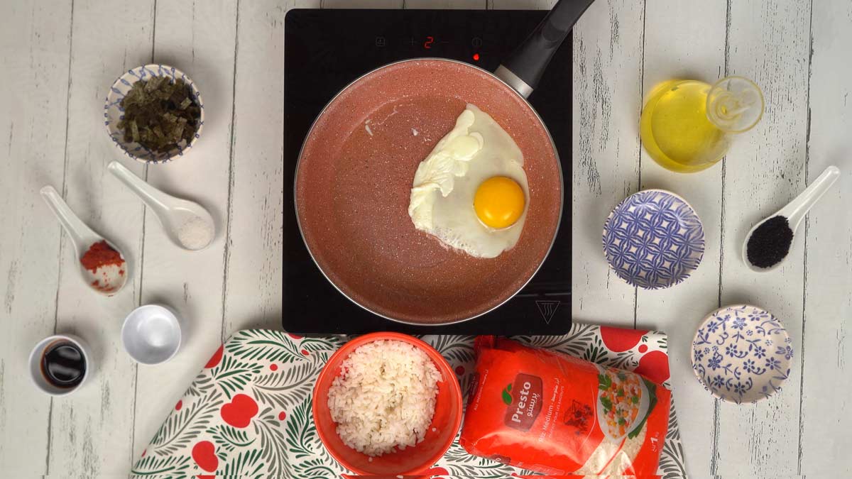 Cuire les œufs Parallèlement, on fait cuire un œuf au plat dans une poêle séparée pour garnir le riz à la fin.