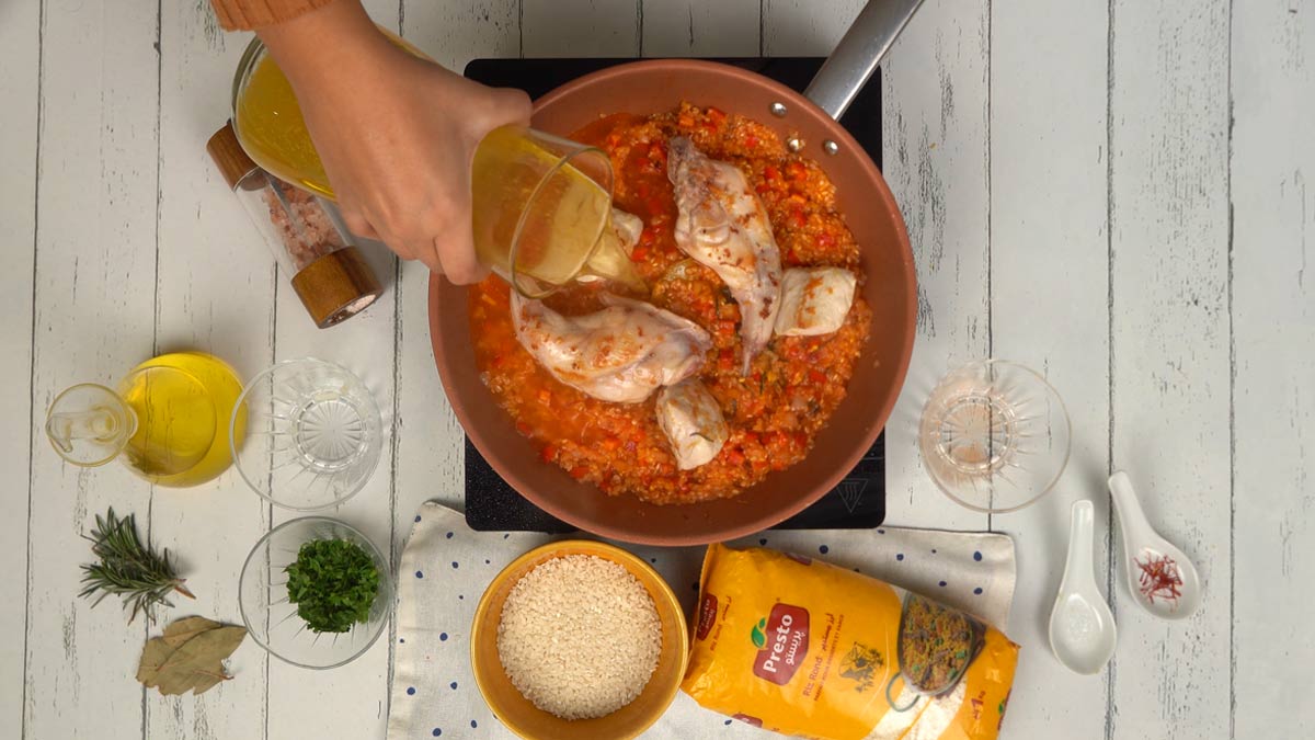 Cuisson On mouille l'ensemble avec un bouillon de volaille parfumé au safran pour donner au riz sa couleur dorée caractéristique.