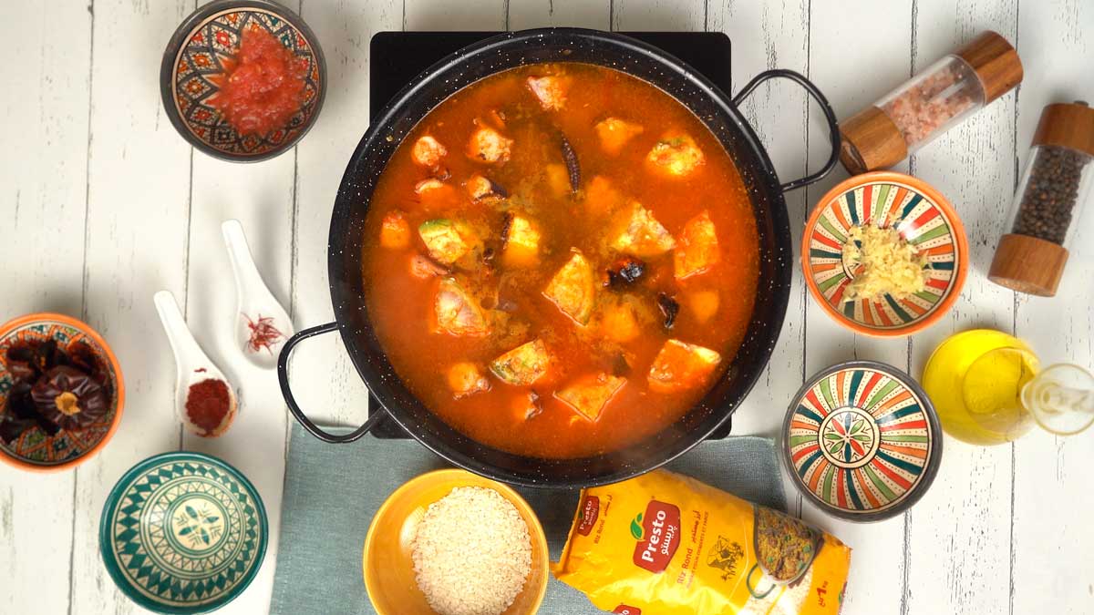On mouille l'ensemble avec un bouillon de poisson bien chaud pour permettre au riz de cuire lentement.