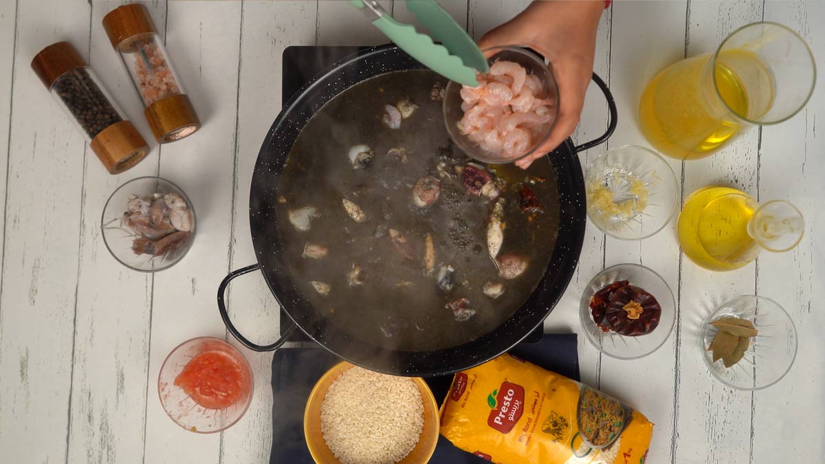 Ajouter les crevettes On dépose délicatement les crevettes sur le dessus pour une cuisson douce à la vapeur du bouillon.