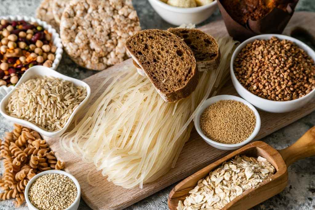 Une alternative aux céréales contenant du gluten Un assortiment varié de produits céréaliers comprenant des nouilles de riz, du pain complet, des galettes de riz, du quinoa, de l'avoine et diverses graines.